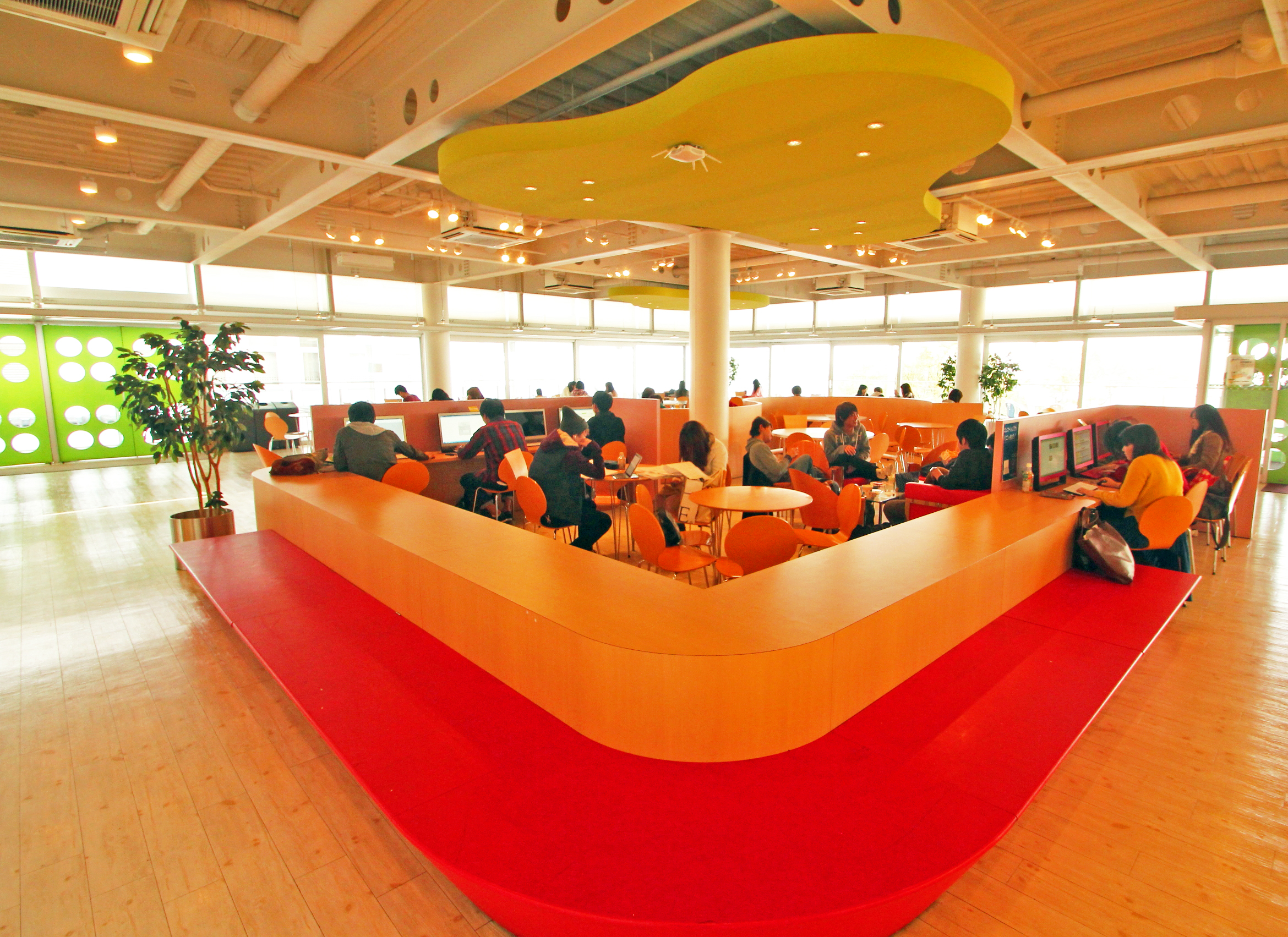 a very modern and swanky student lounge, bright colors and light wood